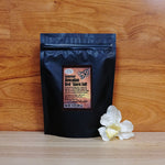 14 oz. Red 'Alaea Kiawe Smoke Sea Salt on a wooden background.